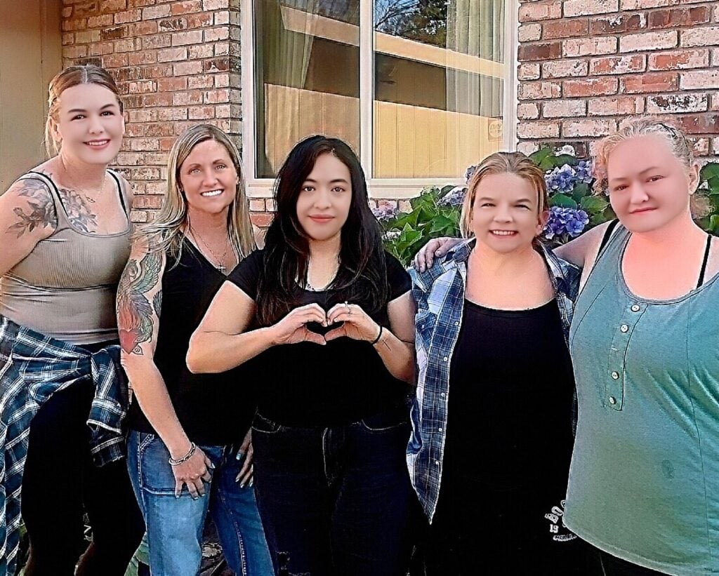 Group of smiling women standing together outdoors.