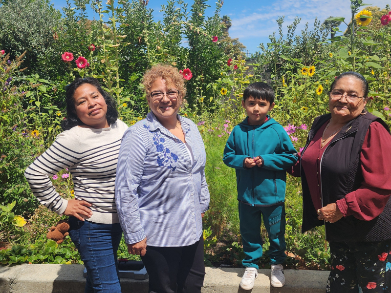 Group enjoying garden with flowers and sunshine.