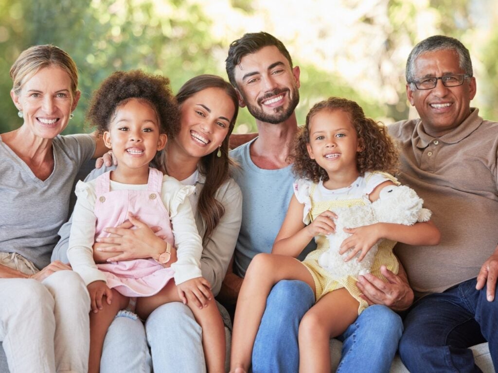 Smiling diverse family sitting together outdoors.